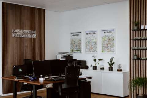 Büro mit zwei Schreibtischen, Monitoren, dekorierten Regalen und Bildern von Herne an der Wand.